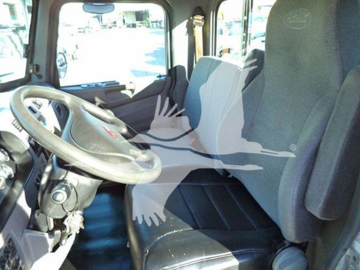 Peterbilt 337 cab interior showing steering wheel and driver's seat with fabric upholstery and dashboard view.