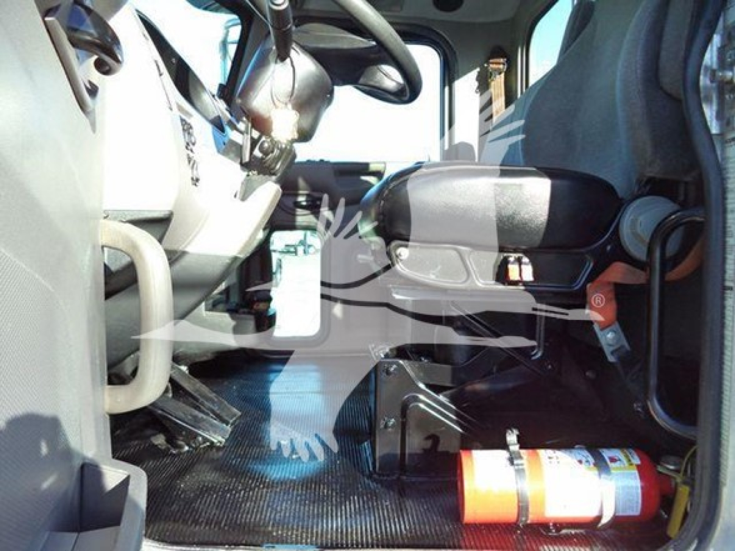 Interior of 2020 Peterbilt 337 cab showing driver seat and dashboard area with a fire extinguisher on the floor