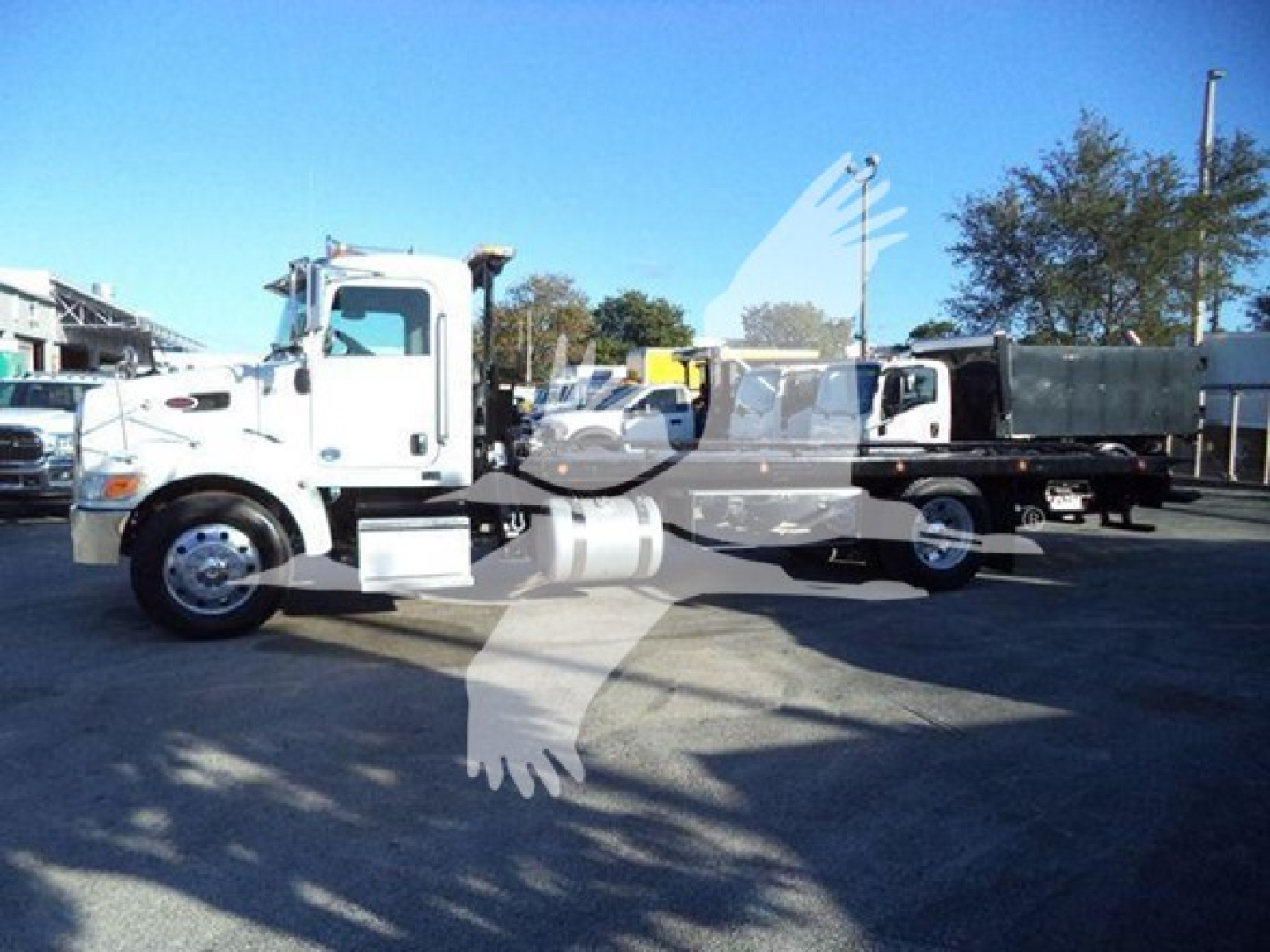 Peterbilt 337 rollback tow truck side view showing cab and long chassis with white paint and chrome wheels