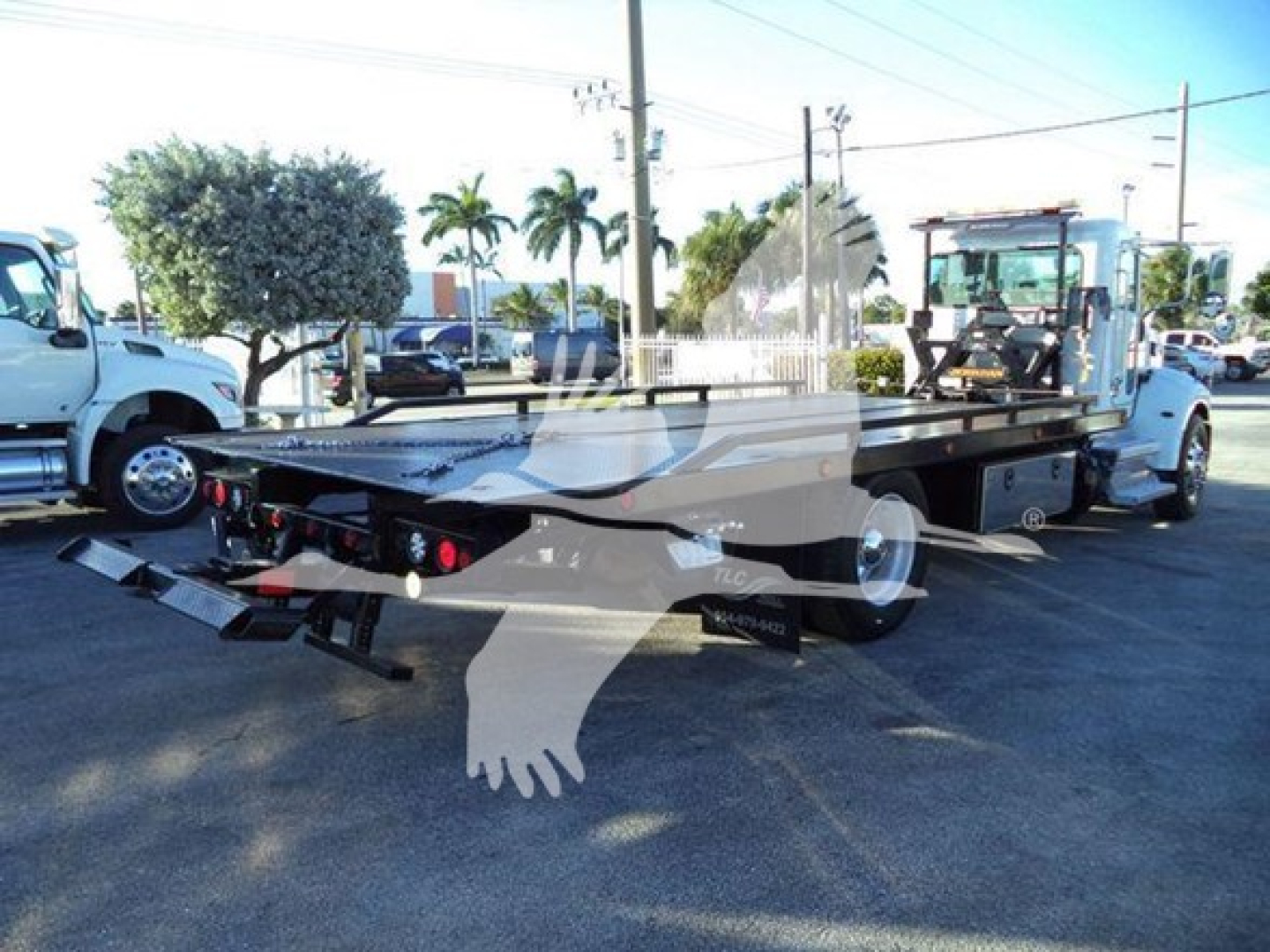 Peterbilt 337 rollback truck flatbed on rear view showing loading ramp, dual rear tires, and towing equipment.
