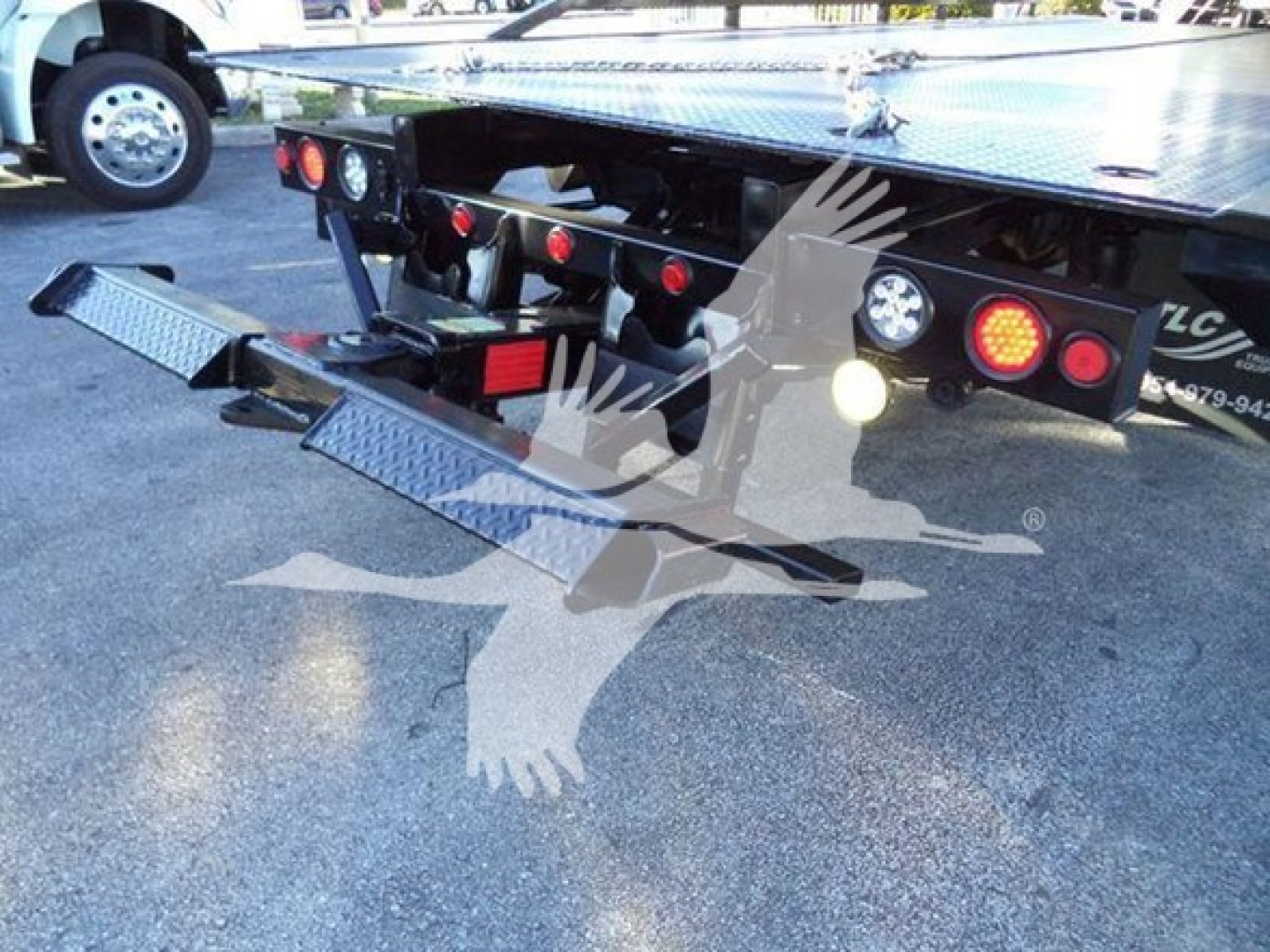 Peterbilt 337 rollback truck rear view showing loading ramps folded down and rear bumper with lights.