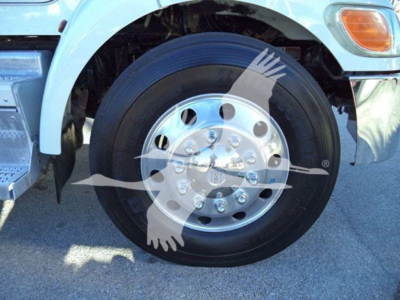 Peterbilt 337 front wheel and tire close-up with chrome hubcap, light blue cab, partial fender, and banner watermark across image.