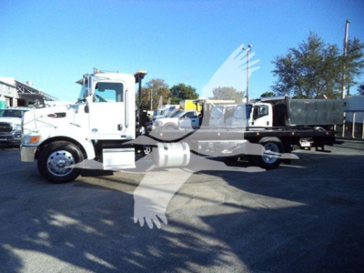 Peterbilt 337 rollback tow truck side view showing cab and long chassis with white paint and chrome wheels