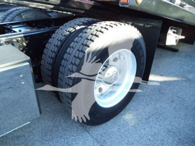 Peterbilt 337 rollback truck wheel and fender showing dual rear tires and wheel mass; part of chassis visible.