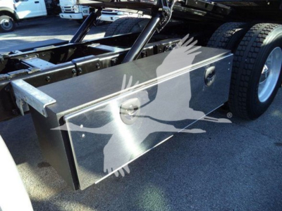 Peterbilt 337 rollback truck chassis with a metal toolbox mounted near the rear wheels, showing a rectangular silver toolbox with recessed handles.