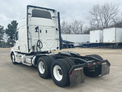 Tractor-trailer cab rear/side view showing Freightliner Cascadia 126 chassis with dual rear axles, mud flaps, and sleeper cab.