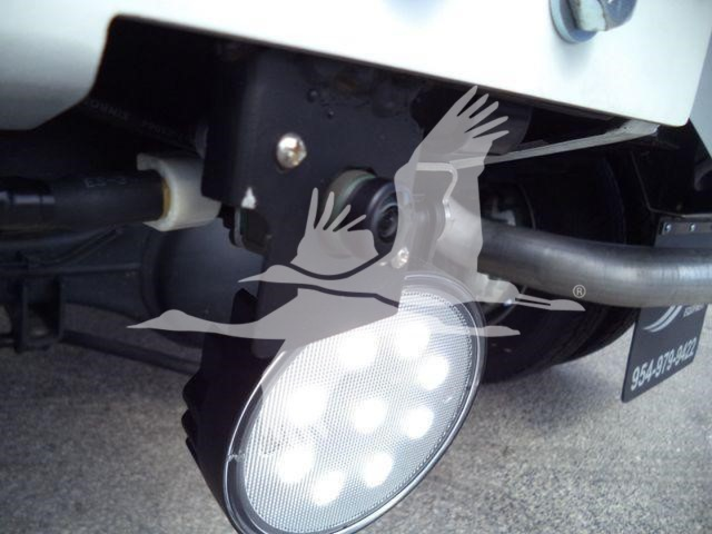 Ram 5500 SLT winch-equipped truck front undercarriage showing round LED work light and mounting bracket