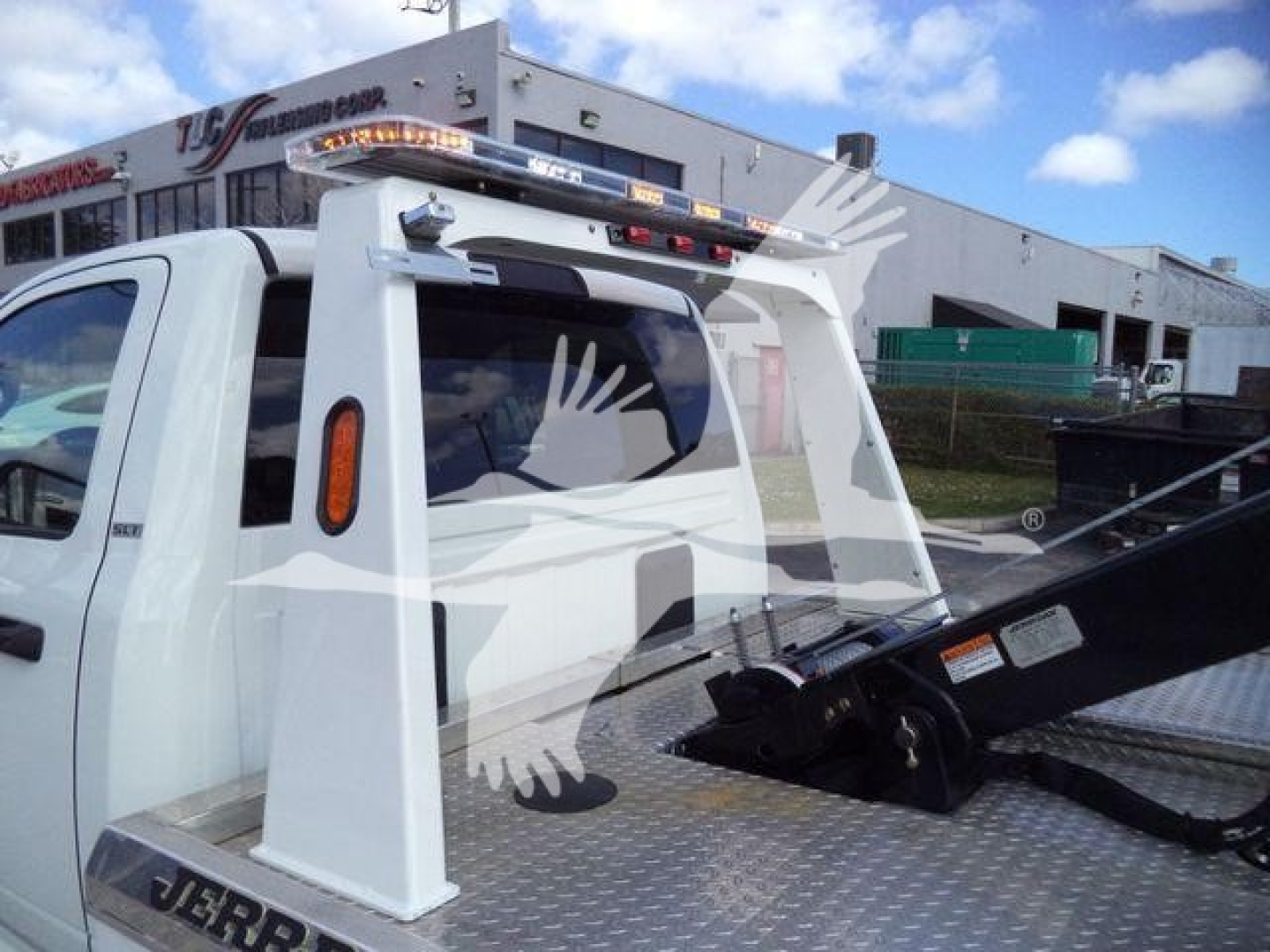 Ram 5500 SLT bed winch setup with white frame and hydraulic boom, cab view, OEM decals and warning labels visible.
