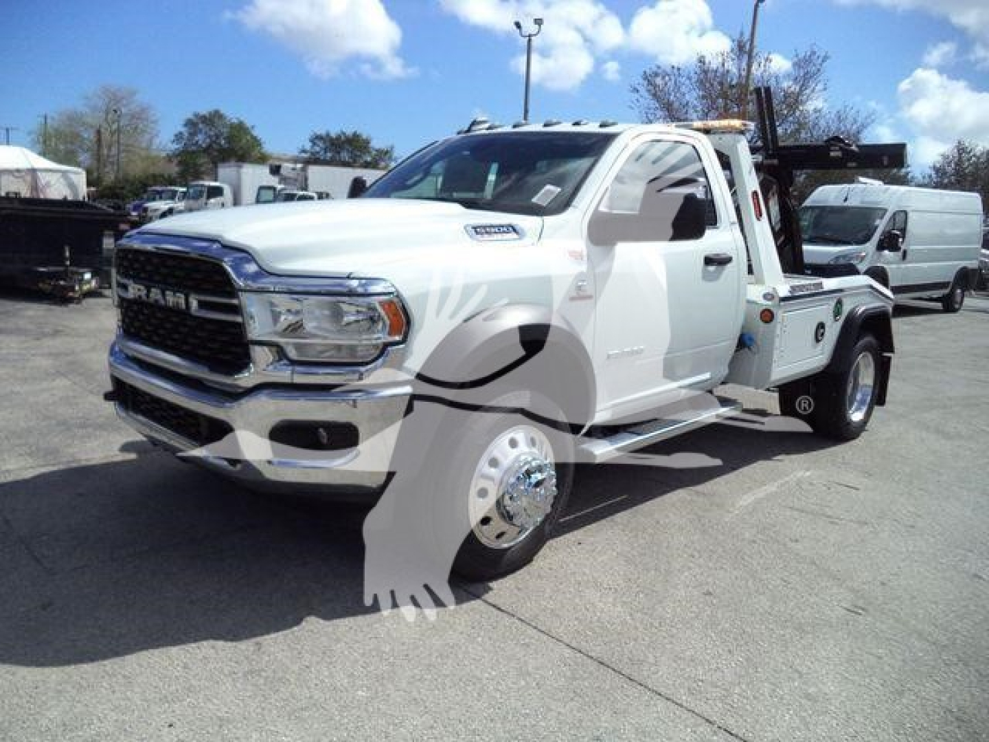 Ram 5500 tow truck in white with front grille RAM emblem, winch-tow setup, side mirrors, dual rear wheels, daytime roadside lot.