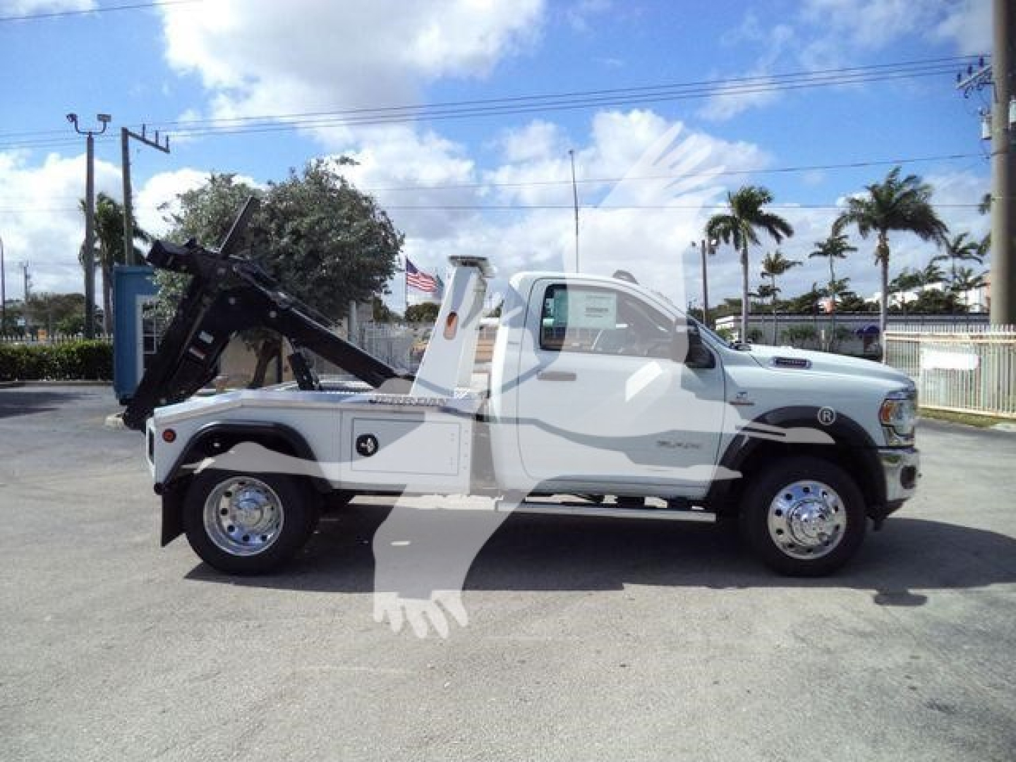Ram 5500 tow truck side view showing winch and rear tilt bed with chrome wheels