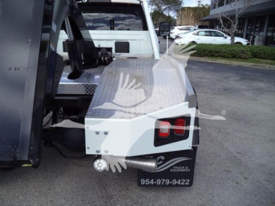 Ram 5500 SLT pickup side with winch equipment and diamond plate deck, rear bumper with two red lights.