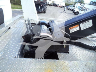 Truck bed winch mounting on a Ram 5500 platform with labels and warning stickers visible on the winch housing.