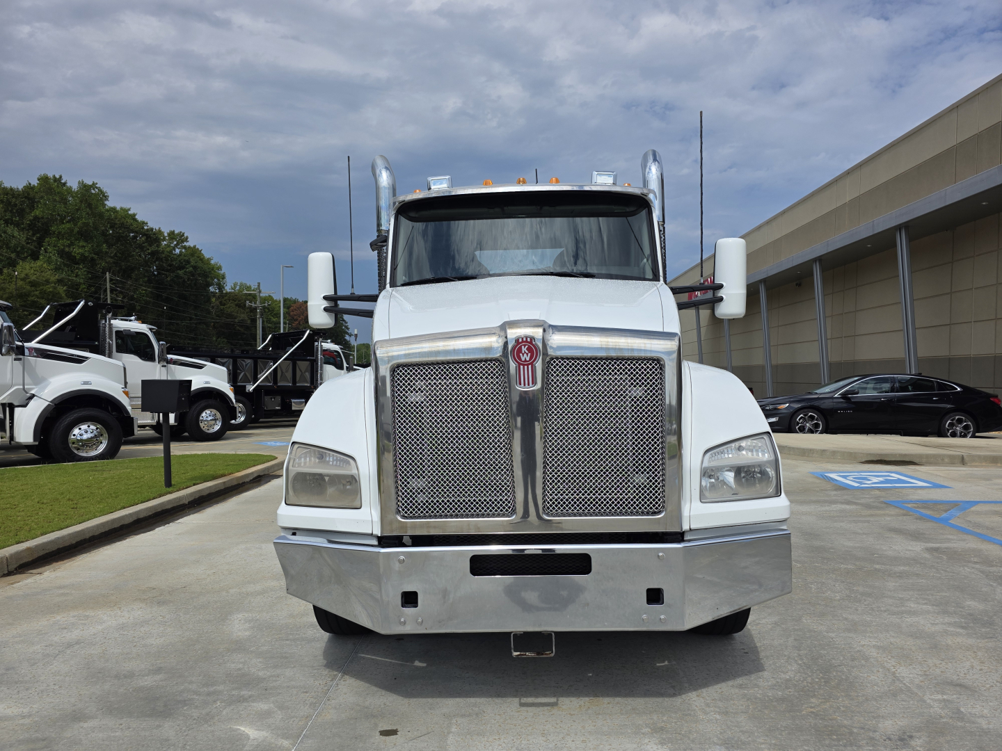 Kenworth T880 conventional daycab front view showing large chrome grille and bumper.
