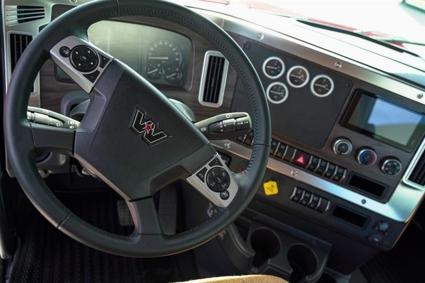 Truck cab dashboard and steering wheel interior of a Western Star 49X showing gauges and controls