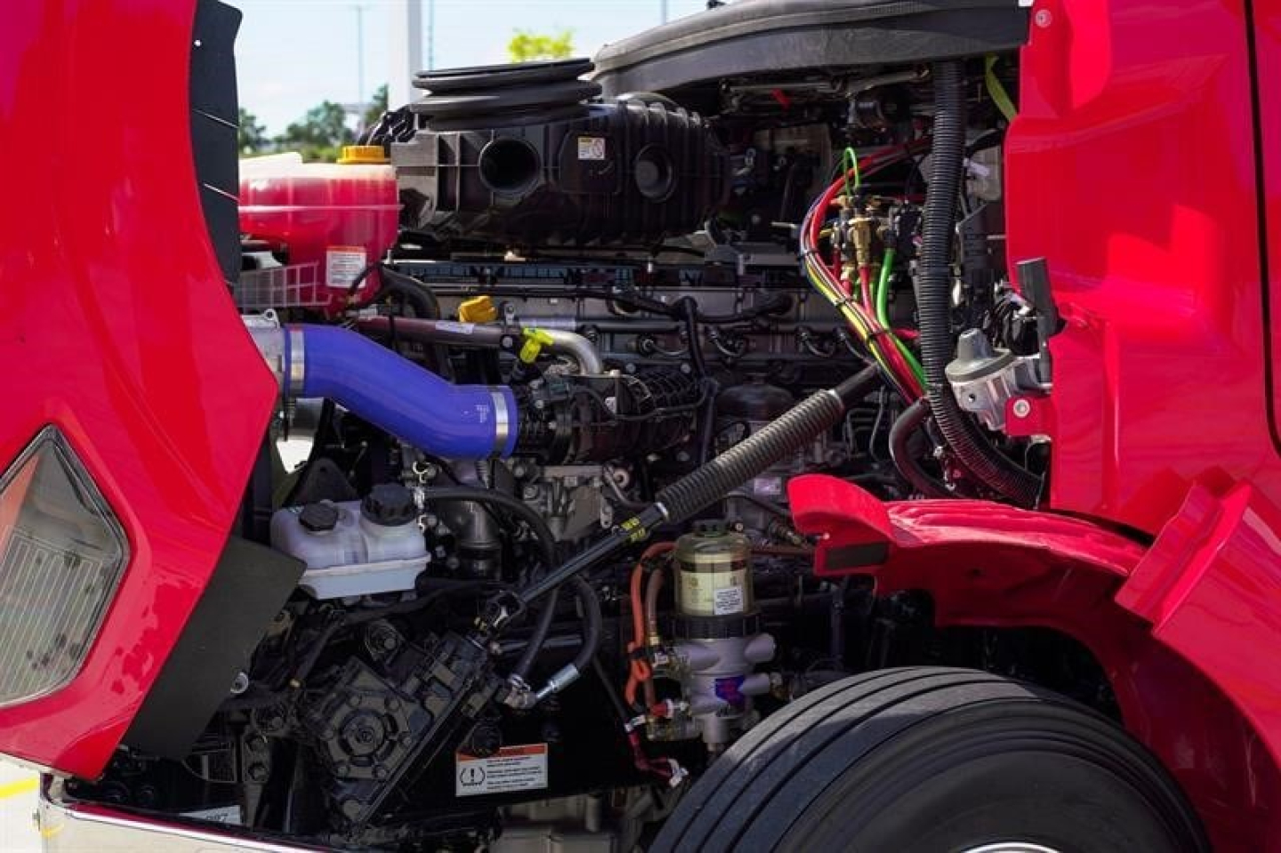 Western Star truck engine bay showing engine components and wiring in red cab