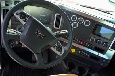Truck cab dashboard and steering wheel interior of a Western Star 49X showing gauges and controls