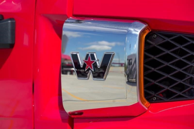 Western Star emblem on a red truck hood with chrome badge and reflections