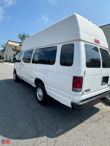 Ford EC3 full-size passenger van rear-side view showing high roof, windows along the side, and rear lights