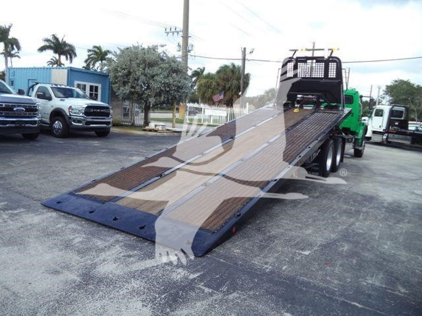 2015 Freightliner M2 106 rollback truck with tilted flatbed in service showing loading ramp and rear cab area.