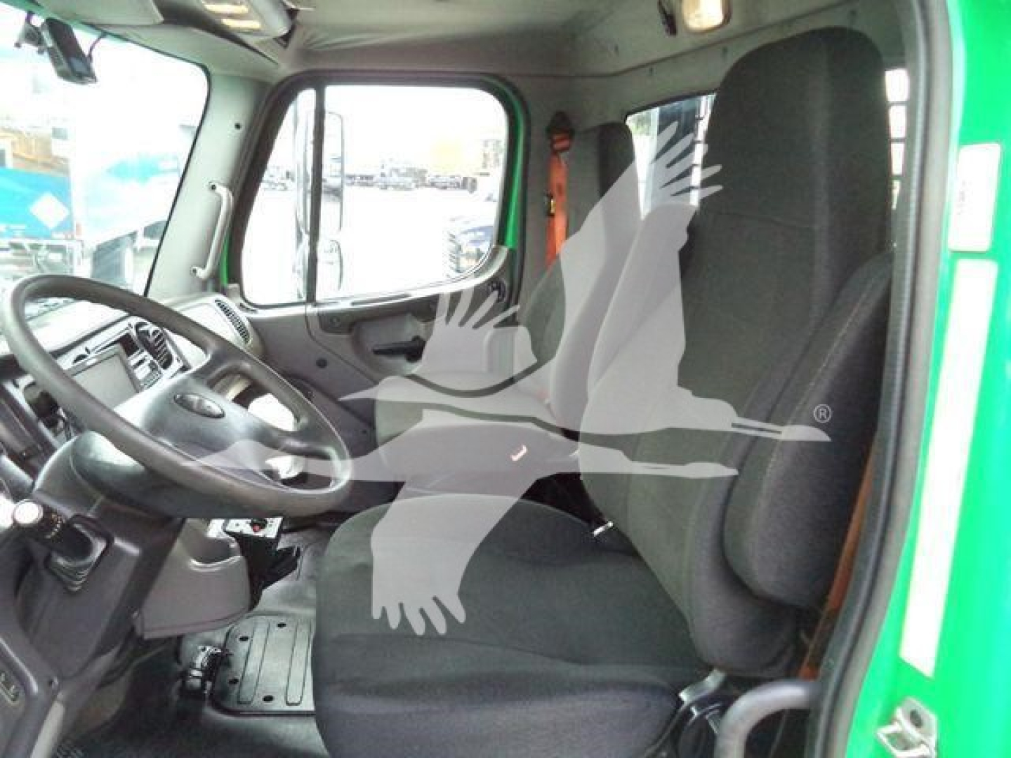 Freightliner M2 106 truck cab interior driver seat and steering wheel, side door window, dashboard view.