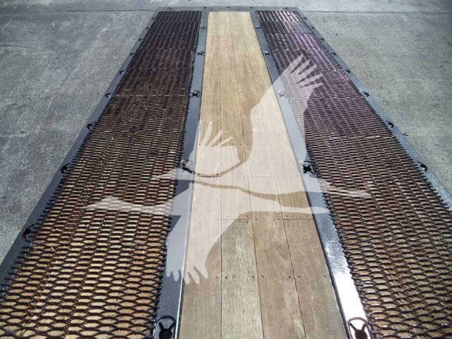 Freightliner M2 106 rollback bed showing grated metal ramps and wooden center planks
