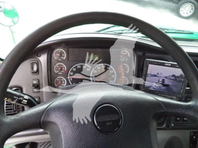 Dashboard view of 2015 Freightliner M2 106 cab with steering wheel, instrument cluster, and side monitor display.