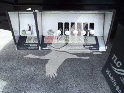 Panel showing multiple control levers and warning labels on Freightliner M2 106 rollback truck chassis; small text labels and knobs visible.
