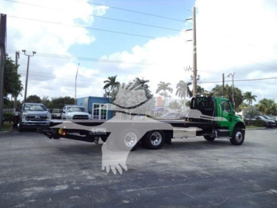Freightliner M2 106 rollback truck with flatbed and green cab, side view showing long flatbed and rear wheels.