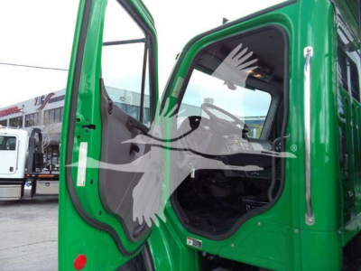 Green Freightliner cab door area of a 2015 M2 106 rollback truck with open door; visible text includes stock number TD9494FM and category/truck information in listing context.