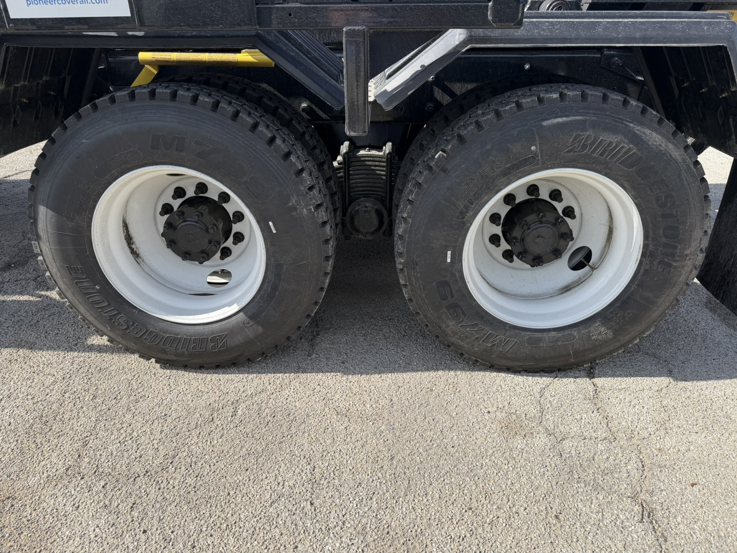 Mack GR64B truck dual rear wheels showing tires and white rims in side view.
