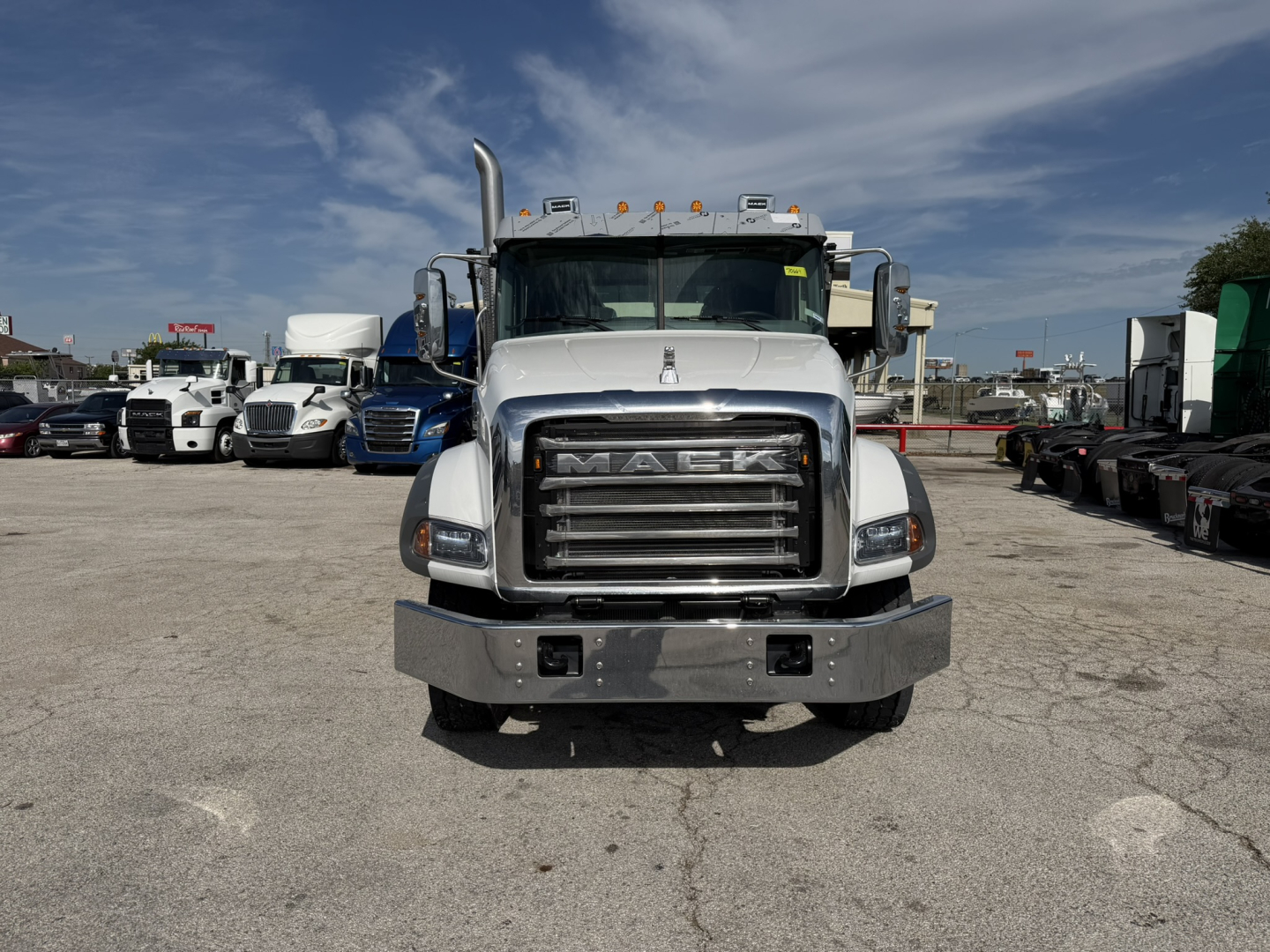 Mack GR64B truck front view showing chrome grille, bumper, and cab with amber clearance lights on top.