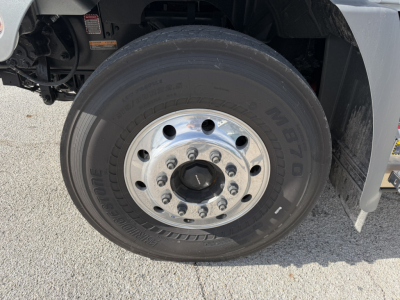 Truck wheel and tire close-up showing front hub with silver steel rim and M+S tire sidewall text.