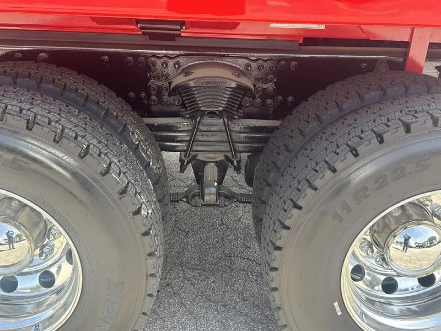 Rear axle and suspension view of a new Western Star 47X dump truck showing dual rear tires, leaf springs, differential housing, and driveline undercarriage.
