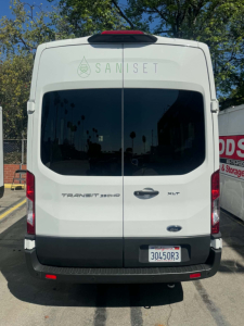 Ford Transit 350 HD rear view showing cargo doors, badges TRAN SIT 350 HD and XLT, California license plate 30450R3, Saniset logo on rear window.