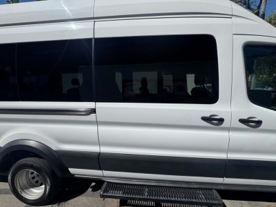 Ford Transit 350 HD passenger van side view showing sliding window and side steps.