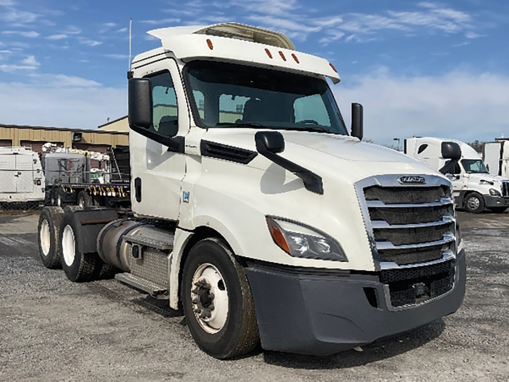 Truck cab showing 2018 Freightliner Cascadia126 daycab with white exterior and black front grille. Side view reveals chassis and dual rear axles.