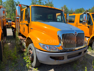 Orange 2012 International 4300 dump truck in a lot, front angled view with chrome grille and dual mirrors.