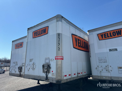 Rear view of a white Wabash van trailer with large orange YELLOW logos on the back and side doors, metal latches, and safety decals visible.