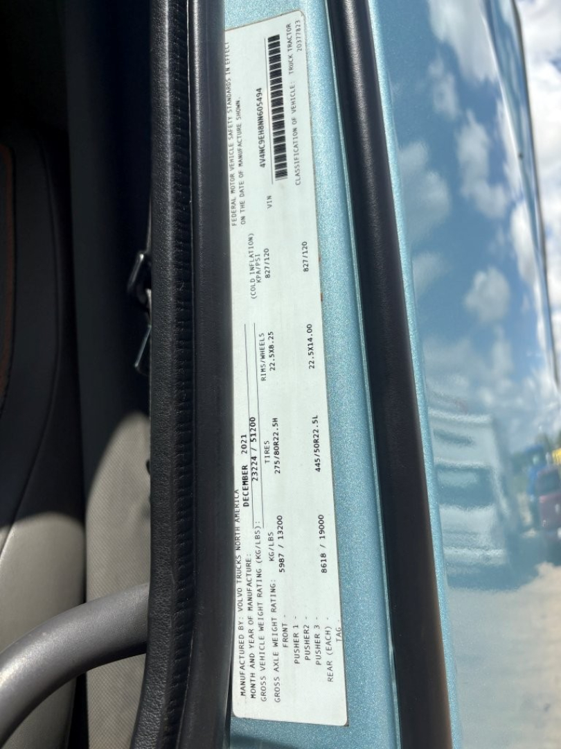 Vehicle information label inside Volvo VNL64T760 cab showing VIN, stock number, and general specs.