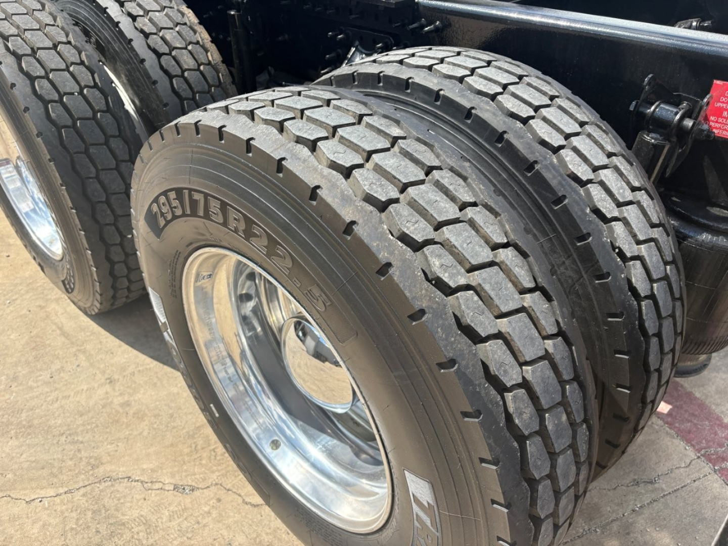 Rear dual tires of a Volvo VNL truck showing Goodyear/Continental tread pattern and polished rims.