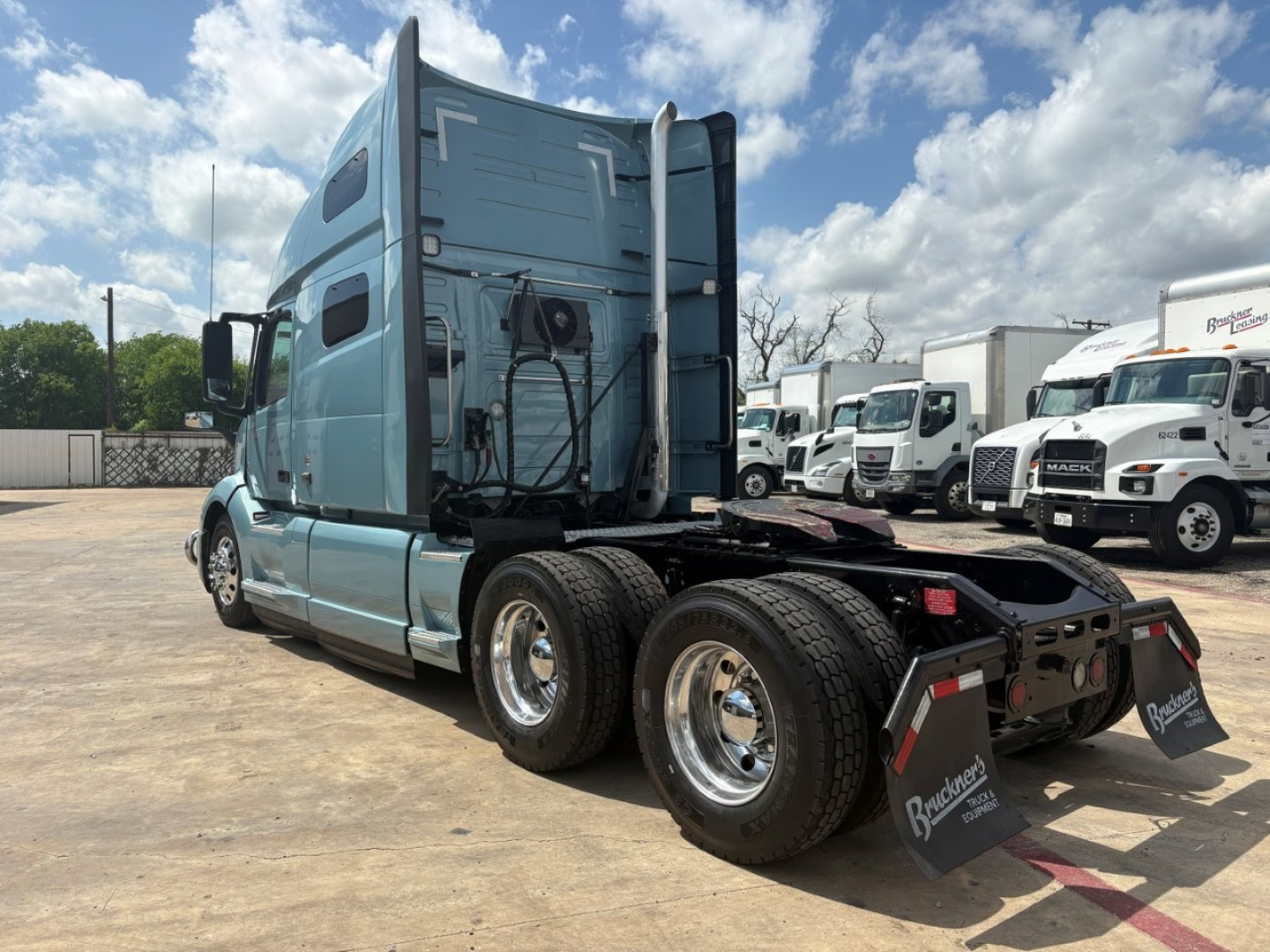 Volvo VNL64T760 truck rear/side view showing sleeper cab and dual rear axles with black chassis and mudflaps.
