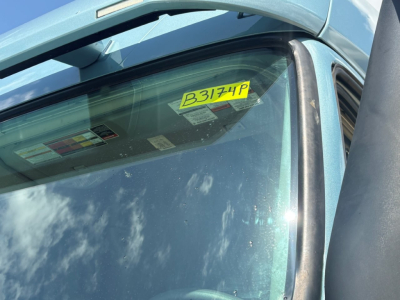 Fleet sticker B3174P on Volvo VNL64T760 windshield showing blue cab and sun glare.