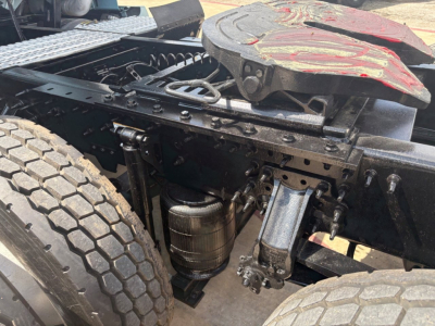 Volvo VNL64T760 truck chassis showing undercarriage components including air tank, rear suspension, and fifth wheel with red wear cover.