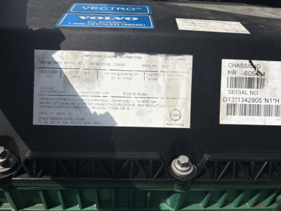 OEM label and engine information plate on Volvo VNL64T760 truck section showing VIN and serial details.