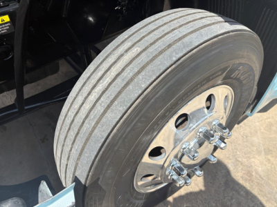 Volvo VNL64T760 truck front wheel showing multi-rib rear dual tires and polished dual wheels with lug nuts.