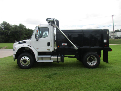 Freightliner M2 106 dump truck side view showing black dump body and white cab