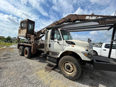 International 74400BA grapple truck showing attached grapple arm and loading bed with cab side and wheels visible.