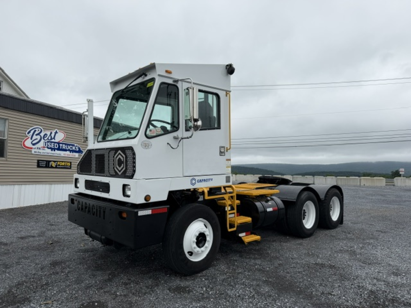 Truck chassis with cab showing TJ6500 Capacity, 3-axle, white cab, black bumper, yellow steps, Pierre crane? visible side decal. 2019 model, VIN 4LMDF7136KL028421.