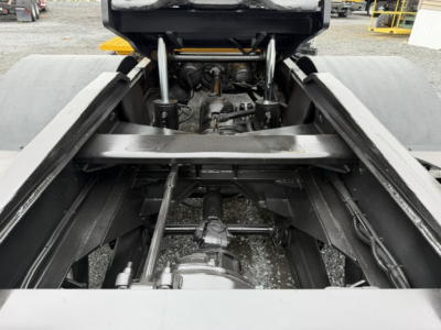 Truck chassis view showing undercarriage, suspension, and drive shaft with hydraulic components.