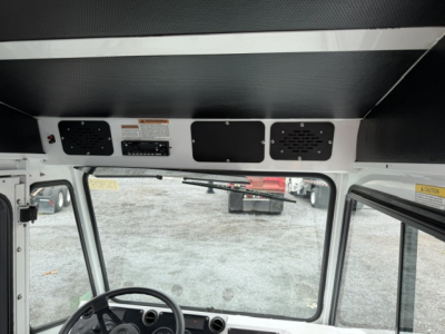 Dashboard area of a TJ6500 yard truck cab showing three vents and control panels above windshield, with warning labels and grille panels.